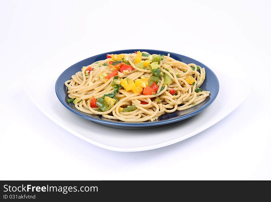 Spaghetti with vegetables on a plate on white background