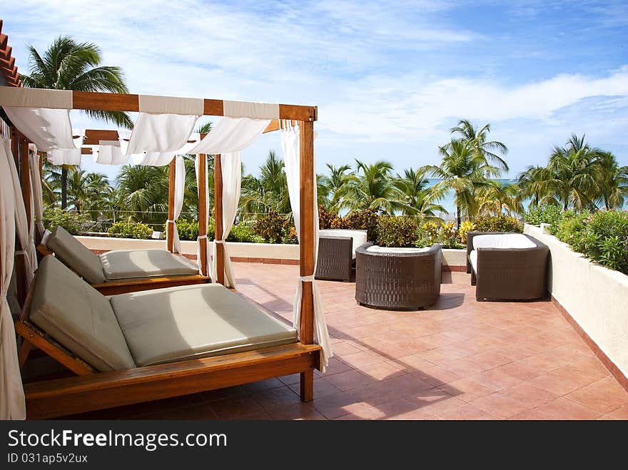 Two cabana beds on the roof overlooking the ocean in the tropics. Two cabana beds on the roof overlooking the ocean in the tropics.