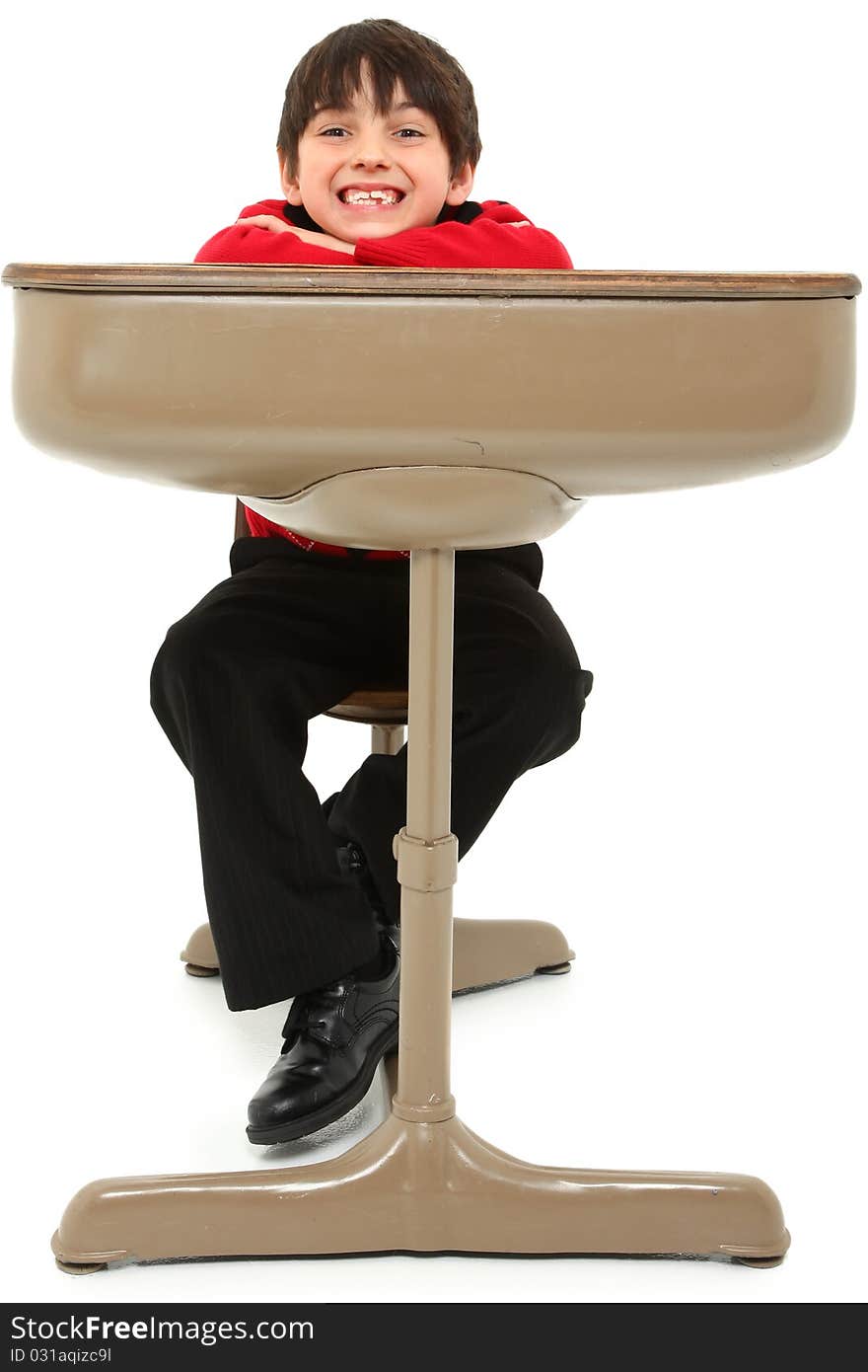 Attractive 7 year old french american boy in school desk over white. Attractive 7 year old french american boy in school desk over white.