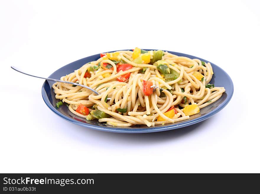 Spaghetti with vegetables being eaten with a fork on white background