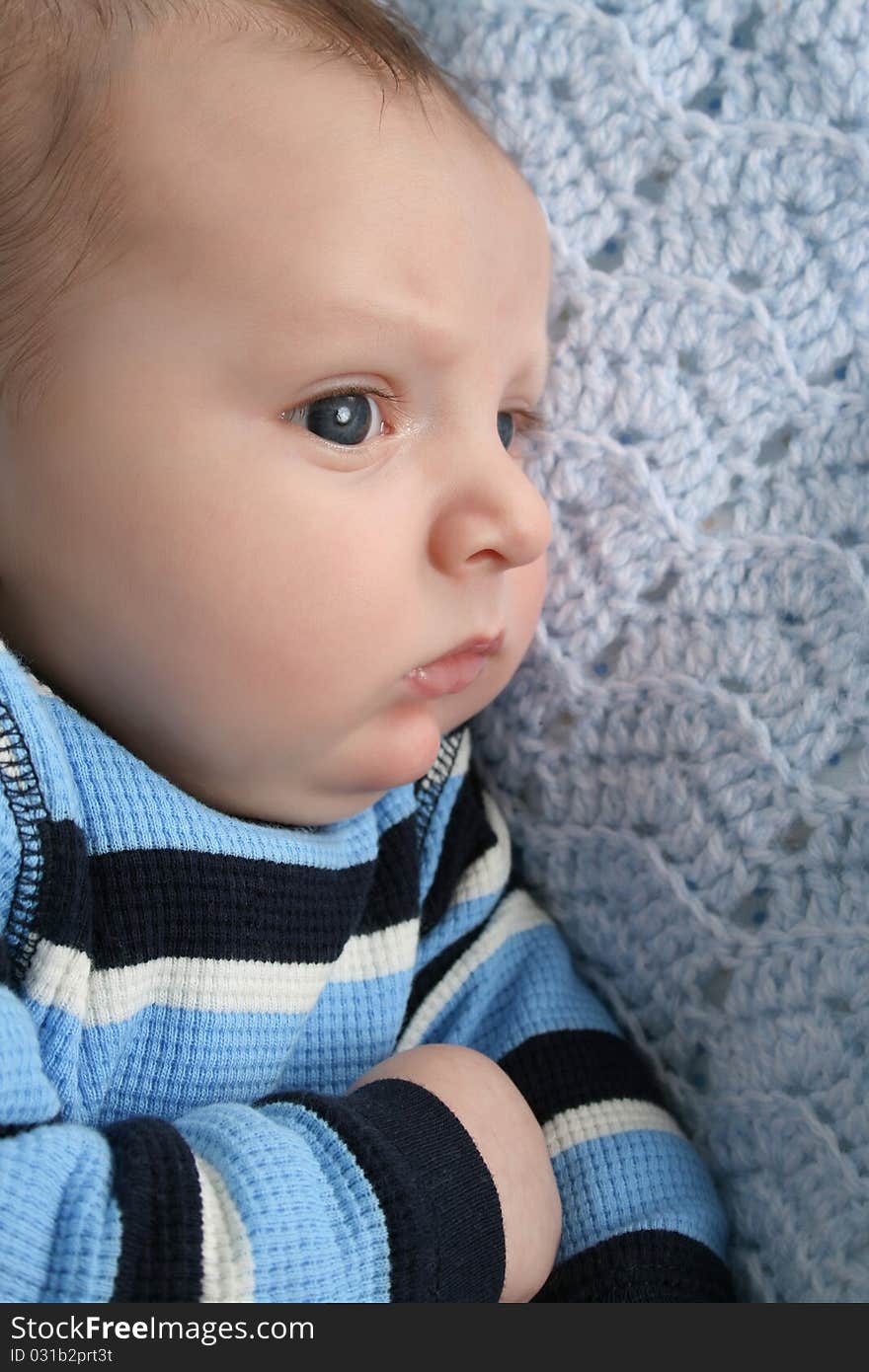 Two month old baby boy lying on a knitted blanket