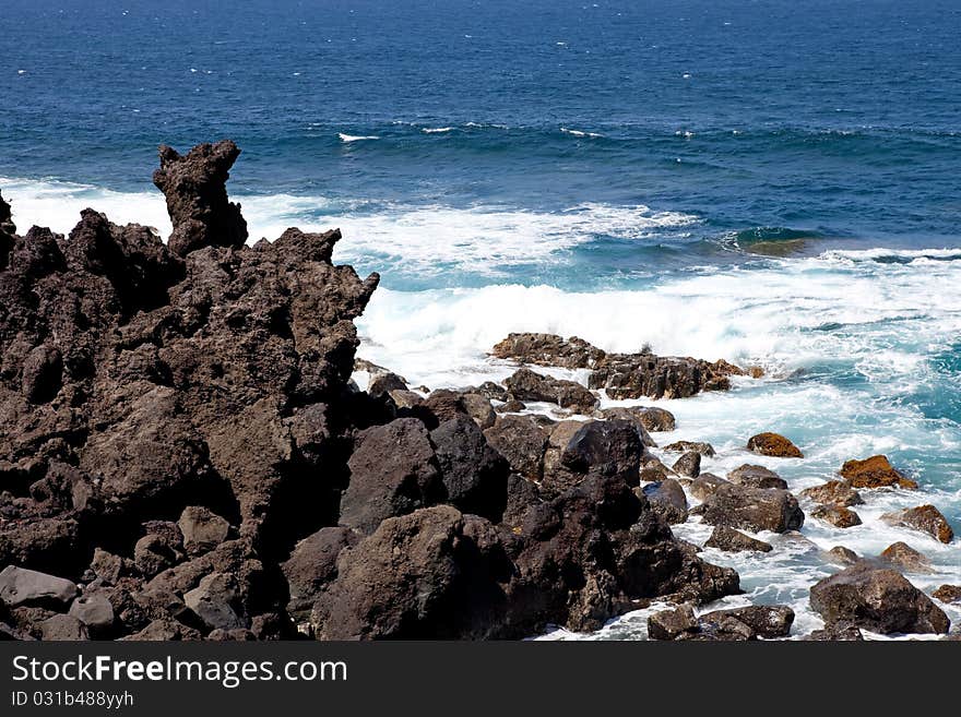 Lanzarote coastline, black rocks on blue sea background, Spain