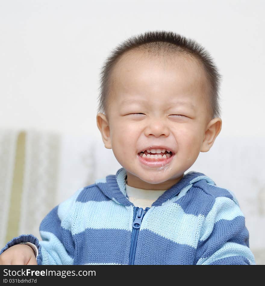 A chinese boy is laughing. he just eat a cake, and some cake scrap is still on his mouth. A chinese boy is laughing. he just eat a cake, and some cake scrap is still on his mouth