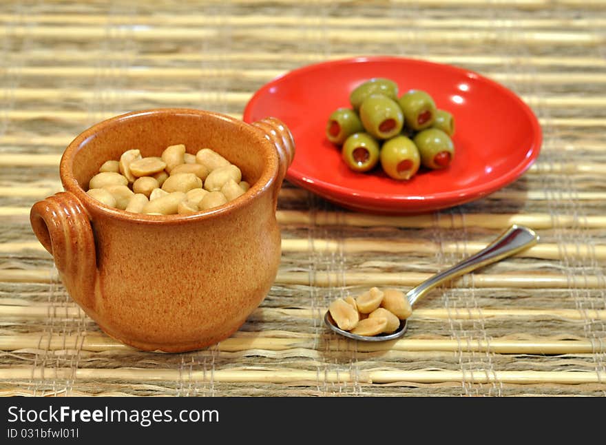 Pot of peanuts and stuffed olives as aperitif