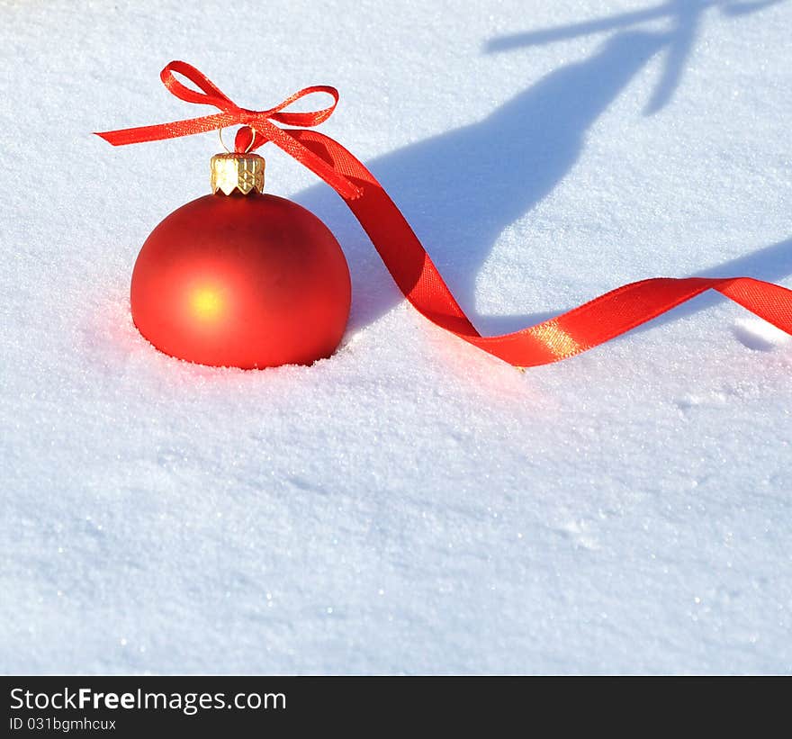 Red Christmas ball on snow