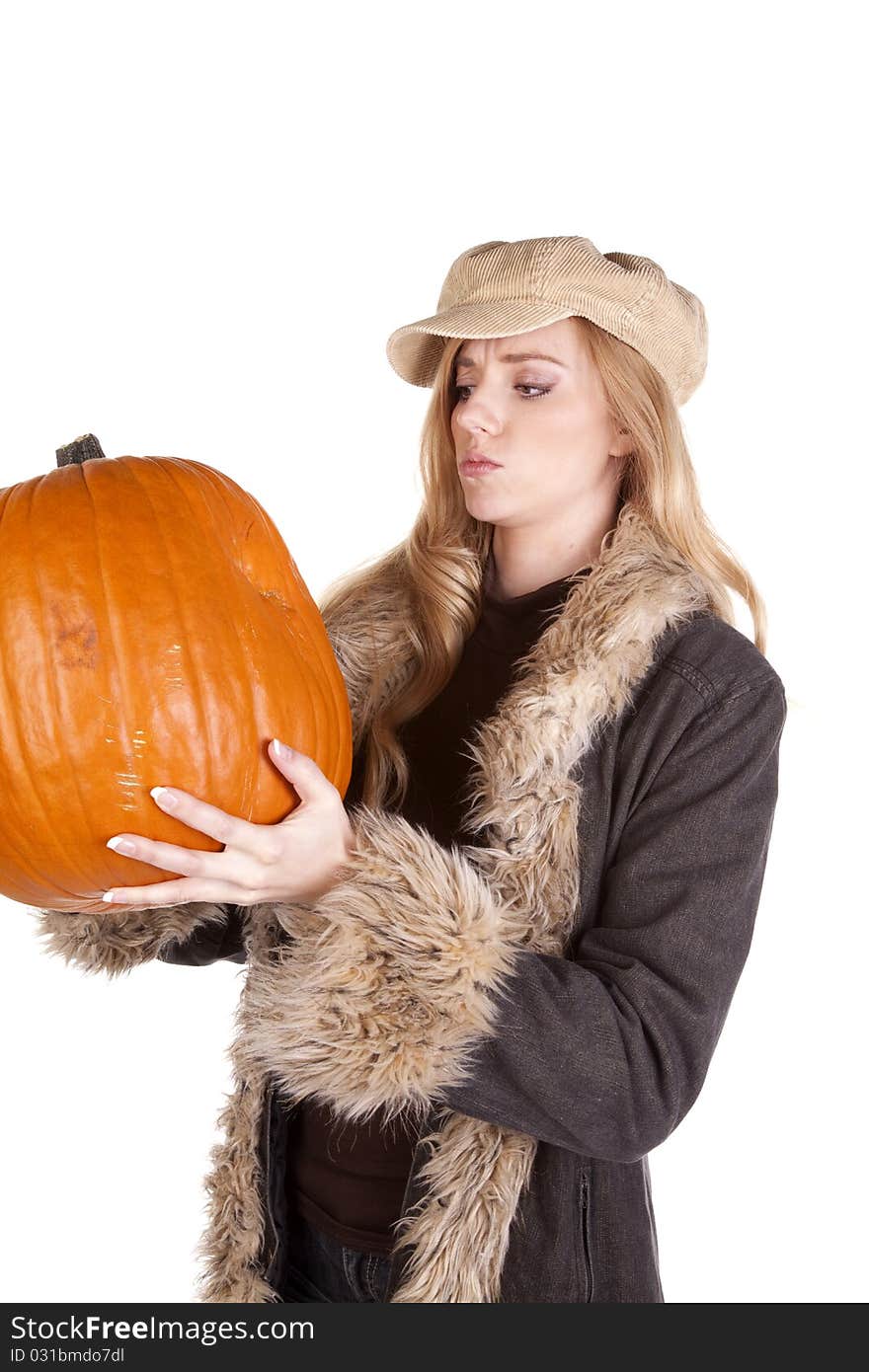 A woman holding and looking at a big pumpkin wondering what to do with it. A woman holding and looking at a big pumpkin wondering what to do with it.