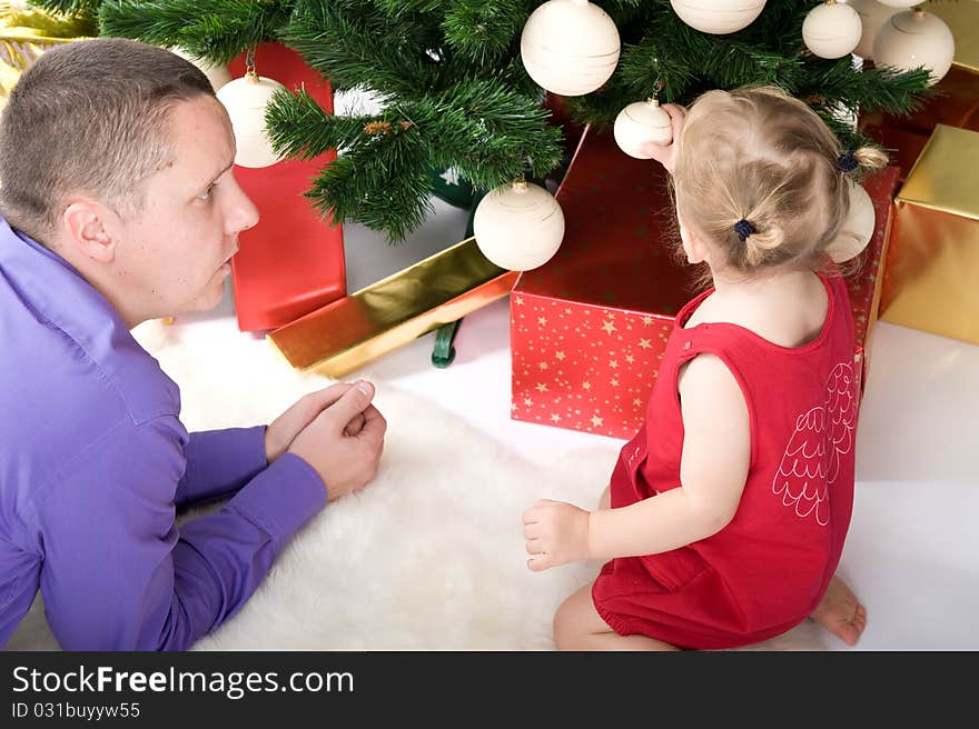 Man with baby under christmas tree