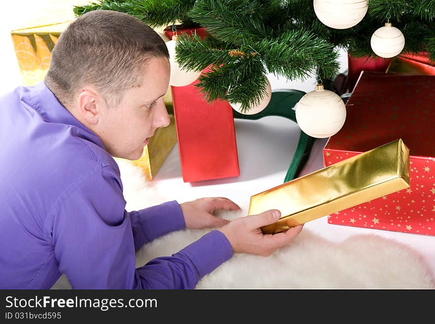 Man with gifts under christmas tree. Man with gifts under christmas tree