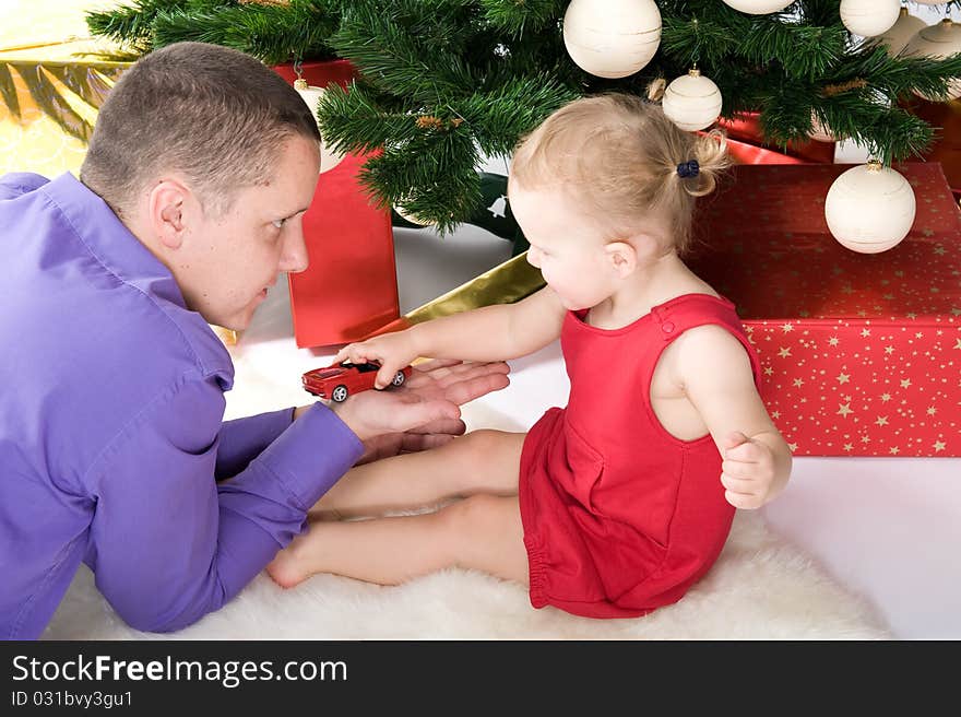 Man with baby under christmas tree