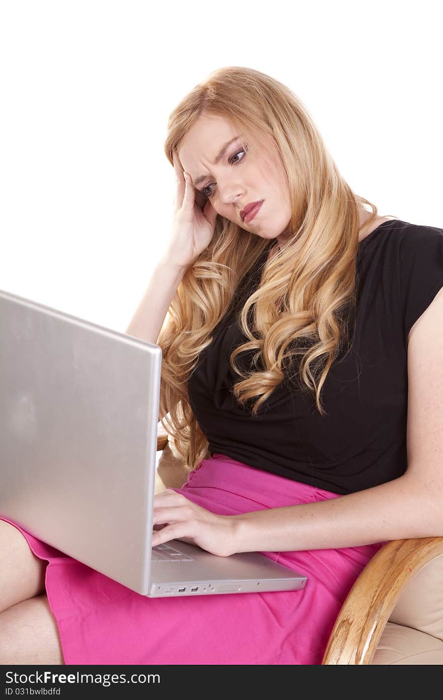 A woman is upset and laying her head on her hand in frustration at her computer. A woman is upset and laying her head on her hand in frustration at her computer.