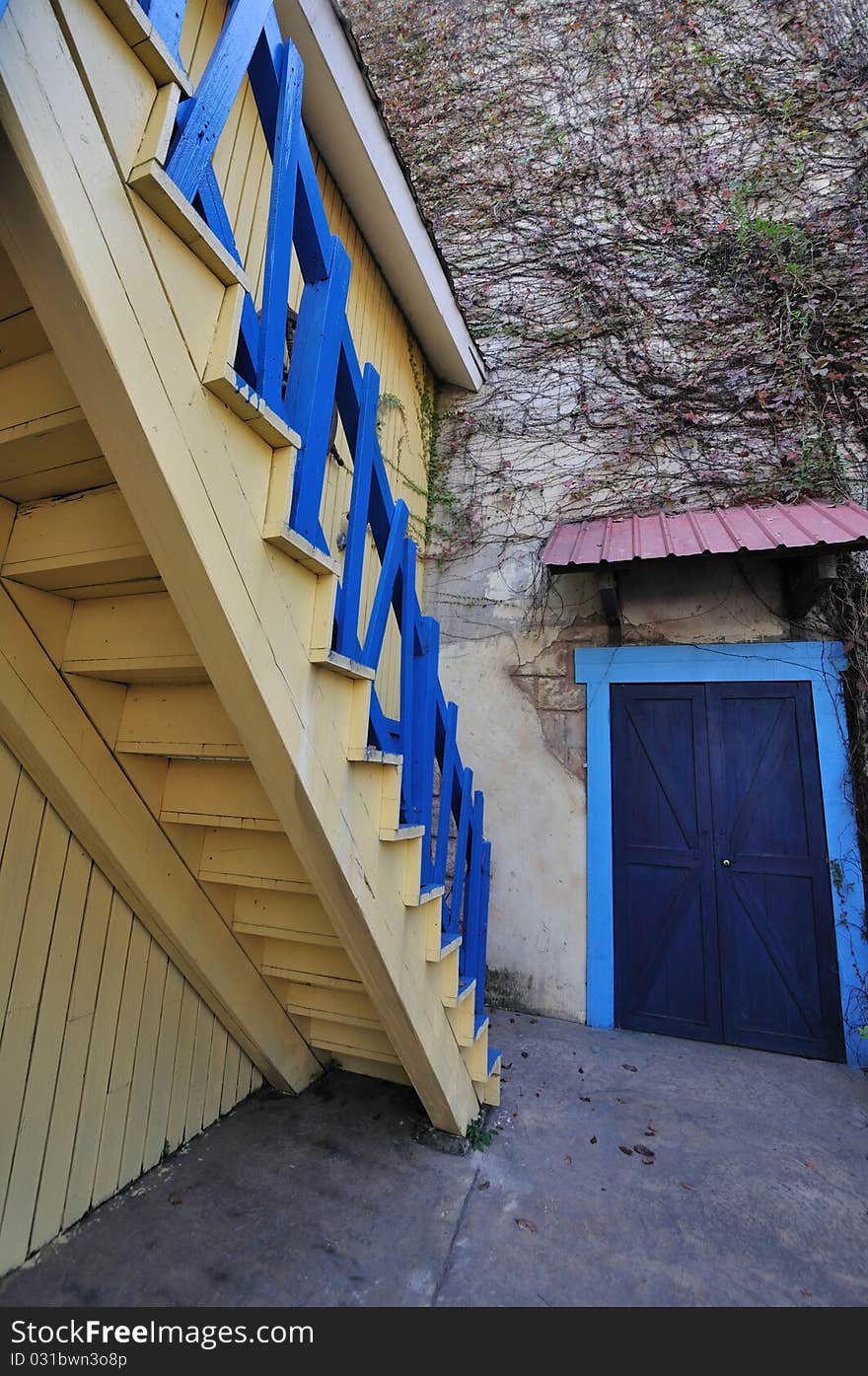 Wooden stair and wall, under wall covered by liane, shown as geometric composition, and wide view angle perspective. Wooden stair and wall, under wall covered by liane, shown as geometric composition, and wide view angle perspective.