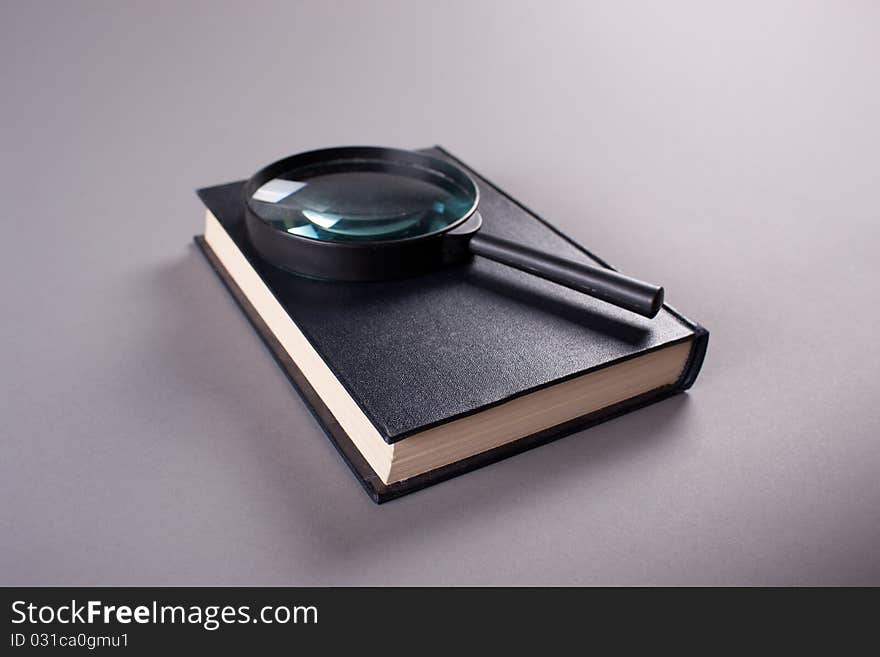 Magnifying Glass On Closed Book