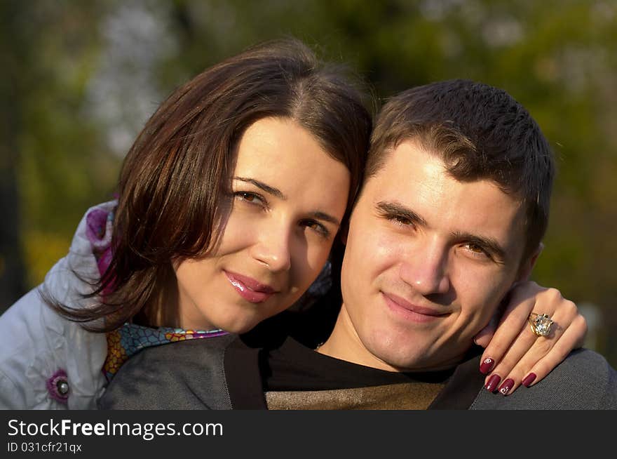 Young couple portrait over defocused autumn park background. Young couple portrait over defocused autumn park background