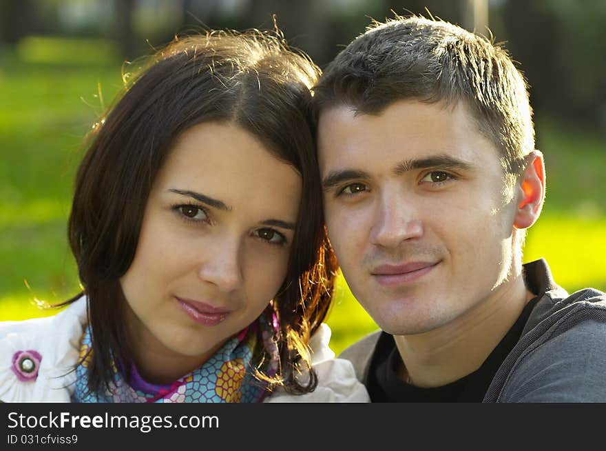 Young couple portrait over defocused autumn park background (backlight). Young couple portrait over defocused autumn park background (backlight)