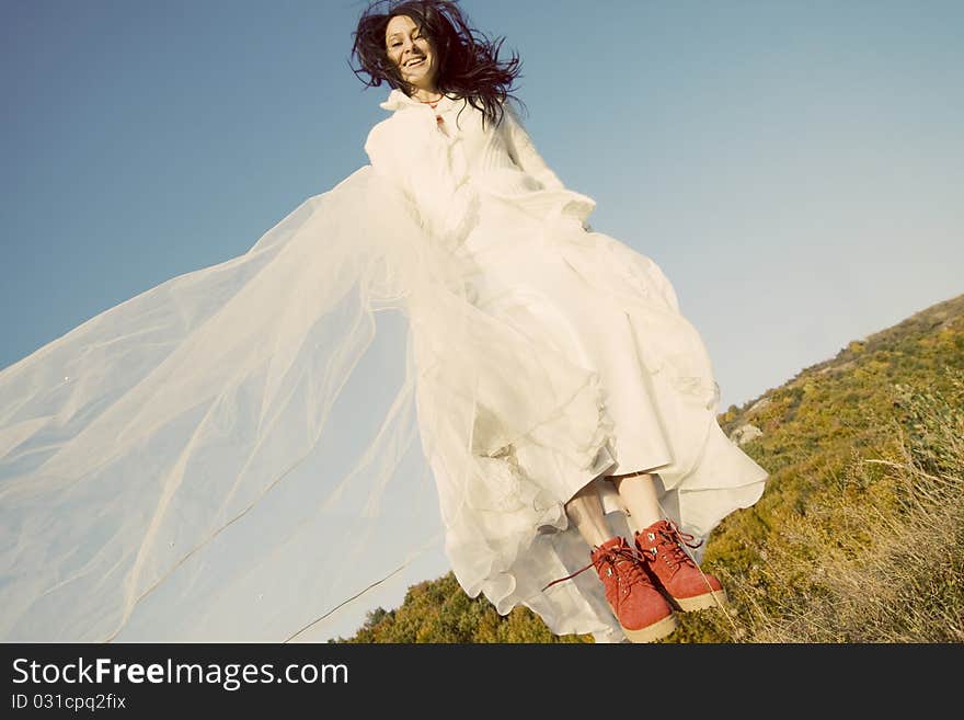 Portrait of romantic woman jumping on field