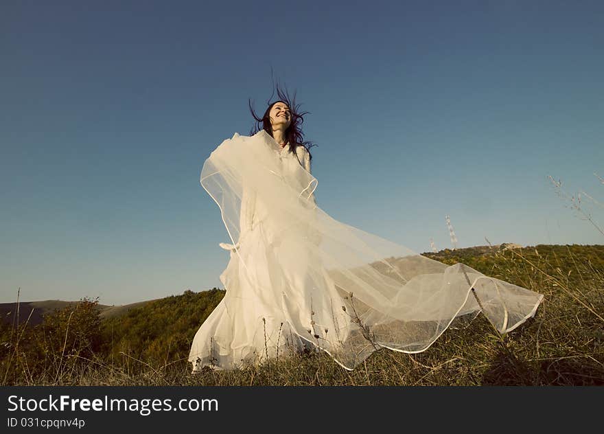 Portrait of romantic woman jumping on field