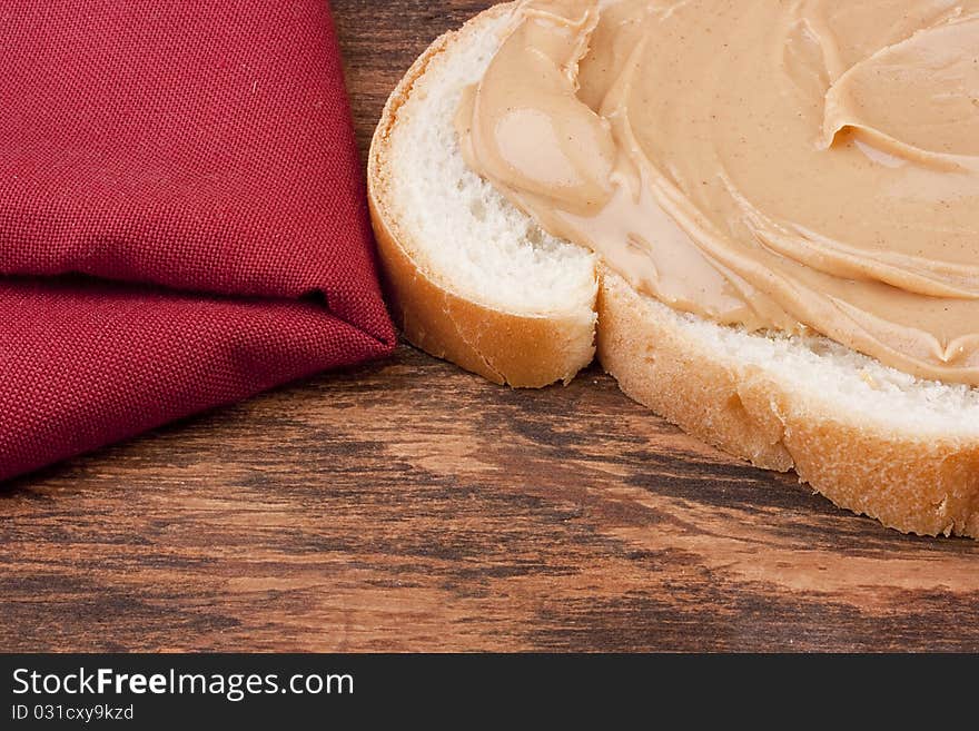 Bread is smeared Peanut butter - a component for a sweet sandwich.