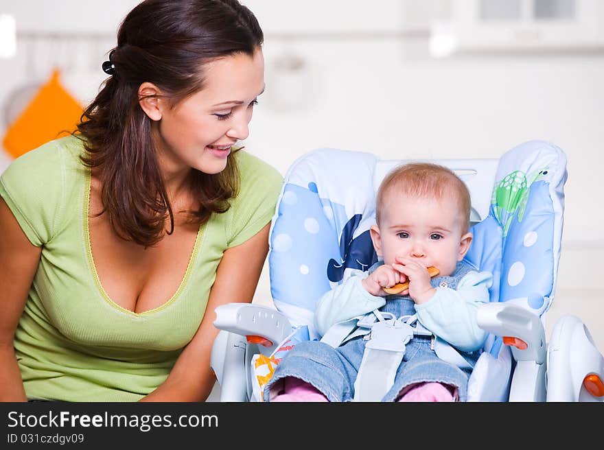 Mother Looking On  Baby In The Highchair