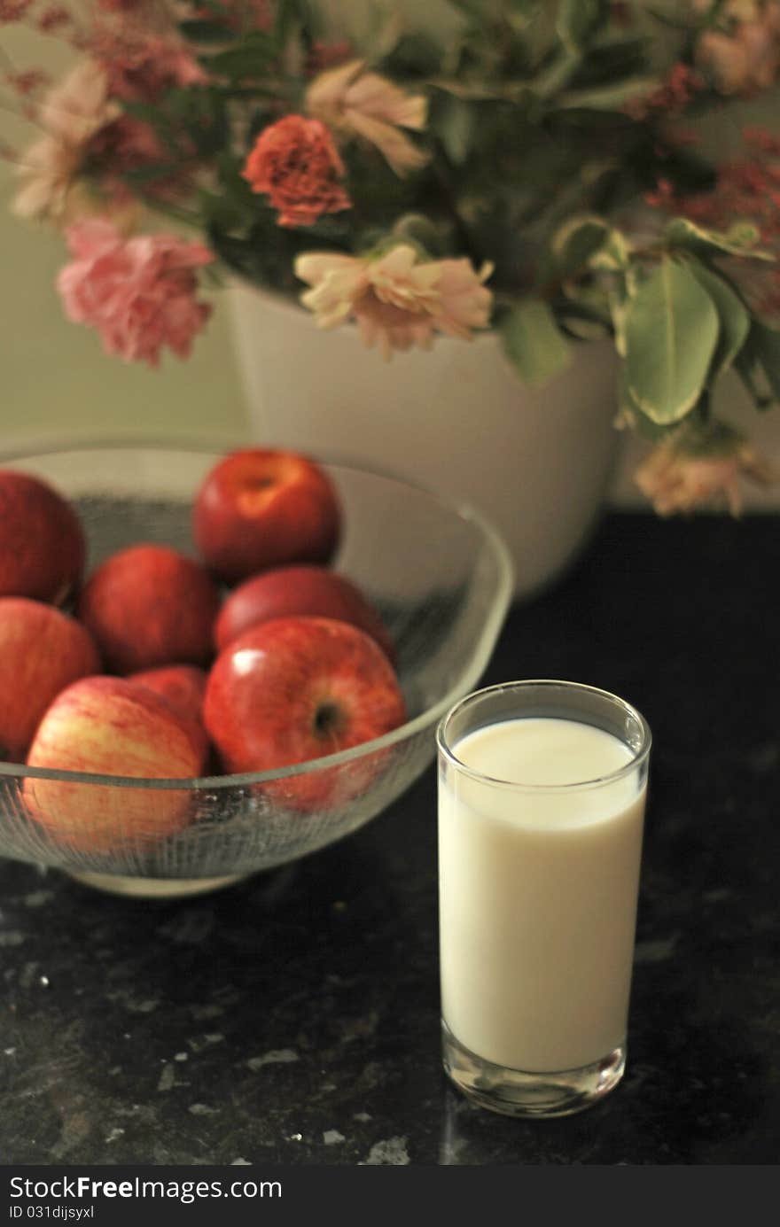 A bowl of apples and a glass of milk shot in natural light. A bowl of apples and a glass of milk shot in natural light