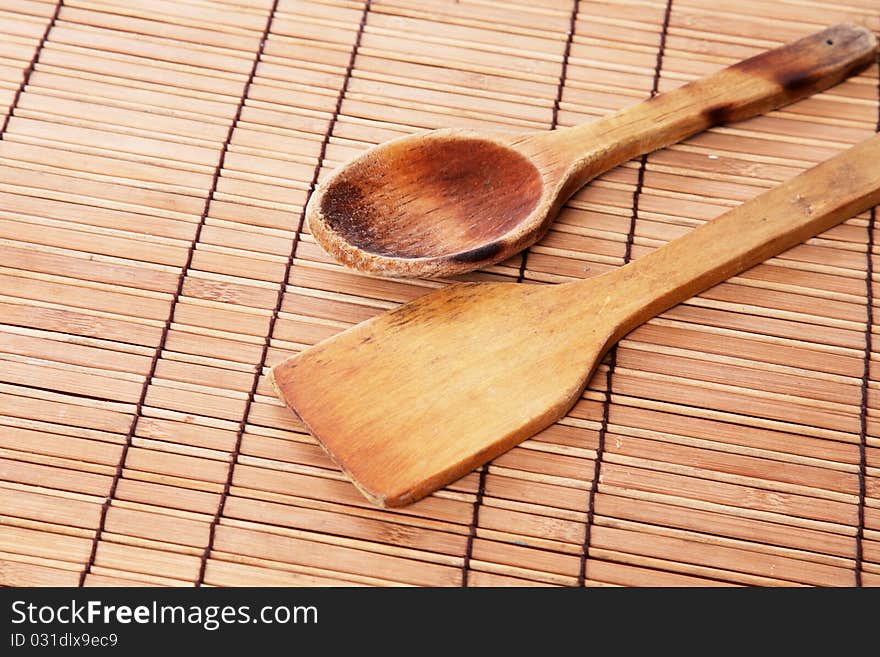 Wooden spoons used and burned over bamboo sticks table