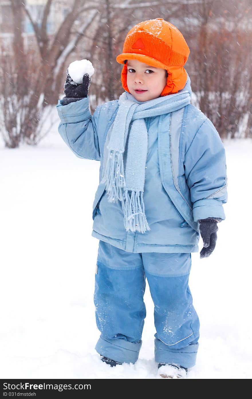 Little boy playing snowballs