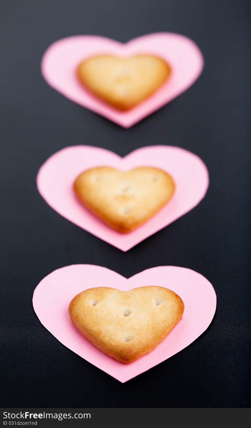 Three crackers on pink paper hearts