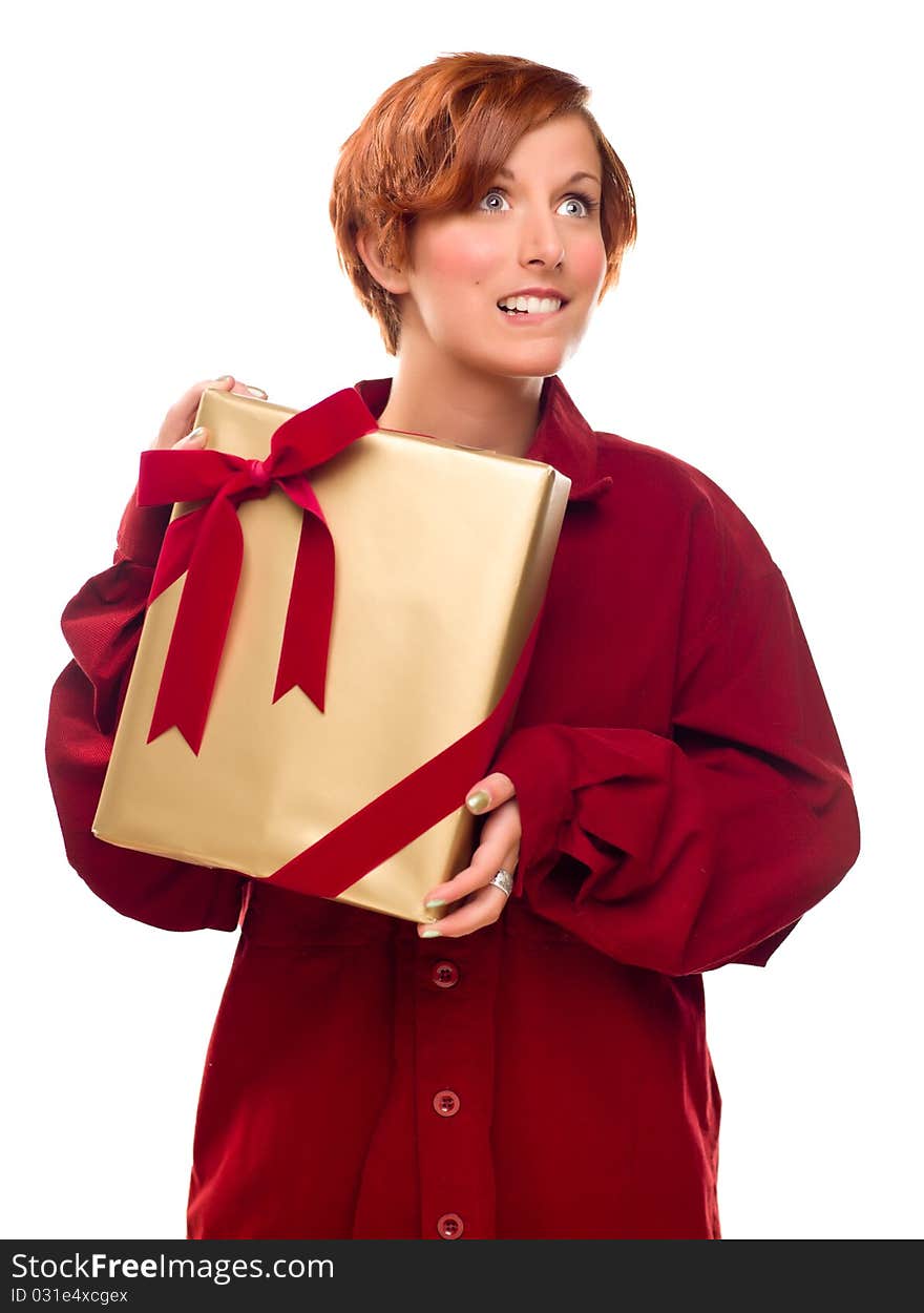 Pretty Red Haired Girl Biting Her Lip Holding Wrapped Gift Isolated on a White Background. Pretty Red Haired Girl Biting Her Lip Holding Wrapped Gift Isolated on a White Background.