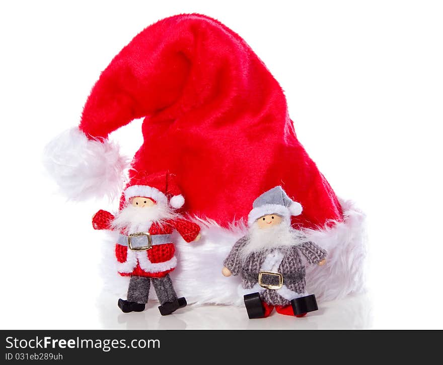 Two santa claus in front of a christmas hat isolated over white. Two santa claus in front of a christmas hat isolated over white