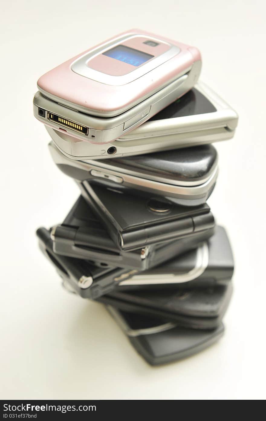 Stack of assorted cellphones on white background. Stack of assorted cellphones on white background