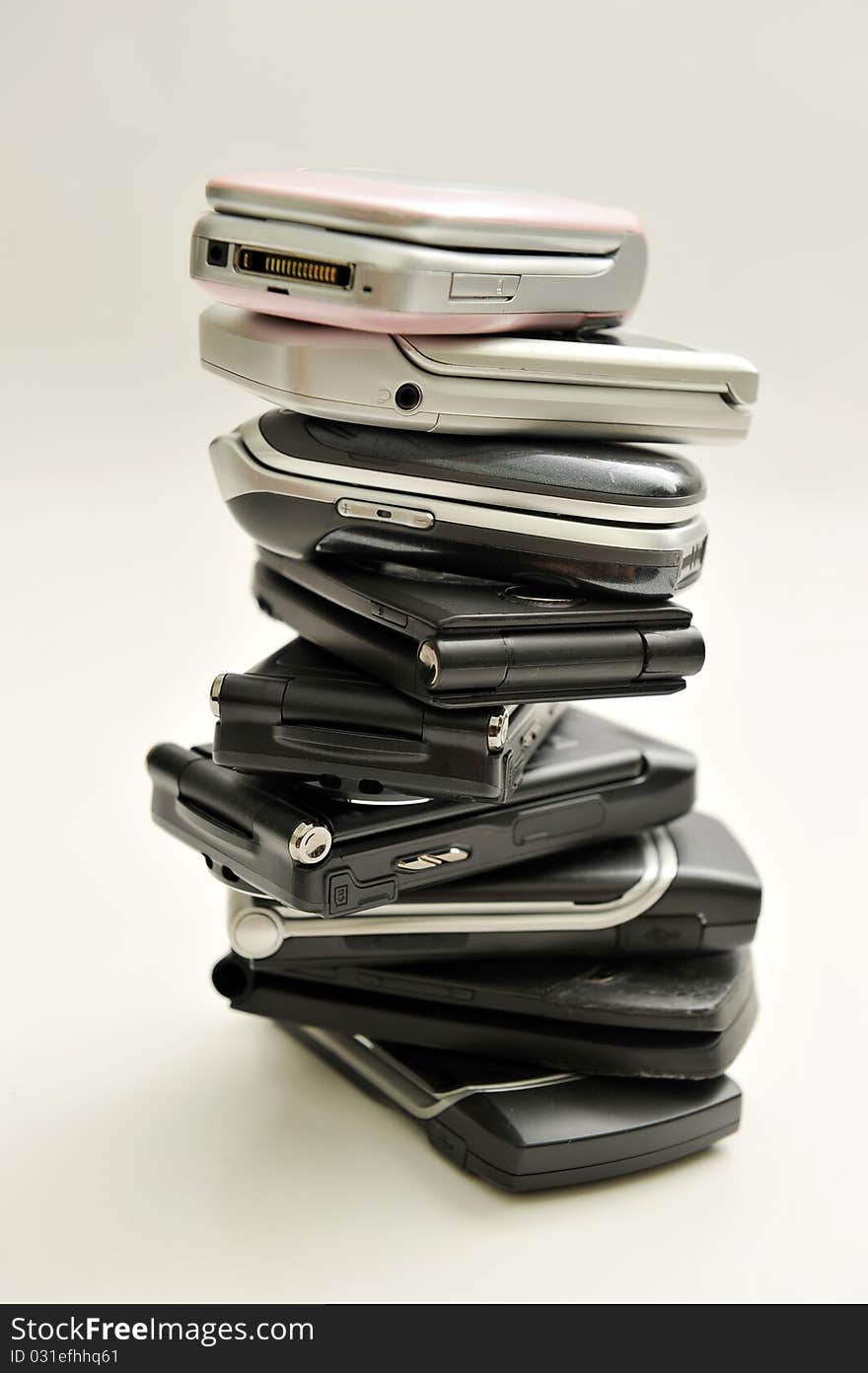 Stack of assorted cellphones on white background. Stack of assorted cellphones on white background