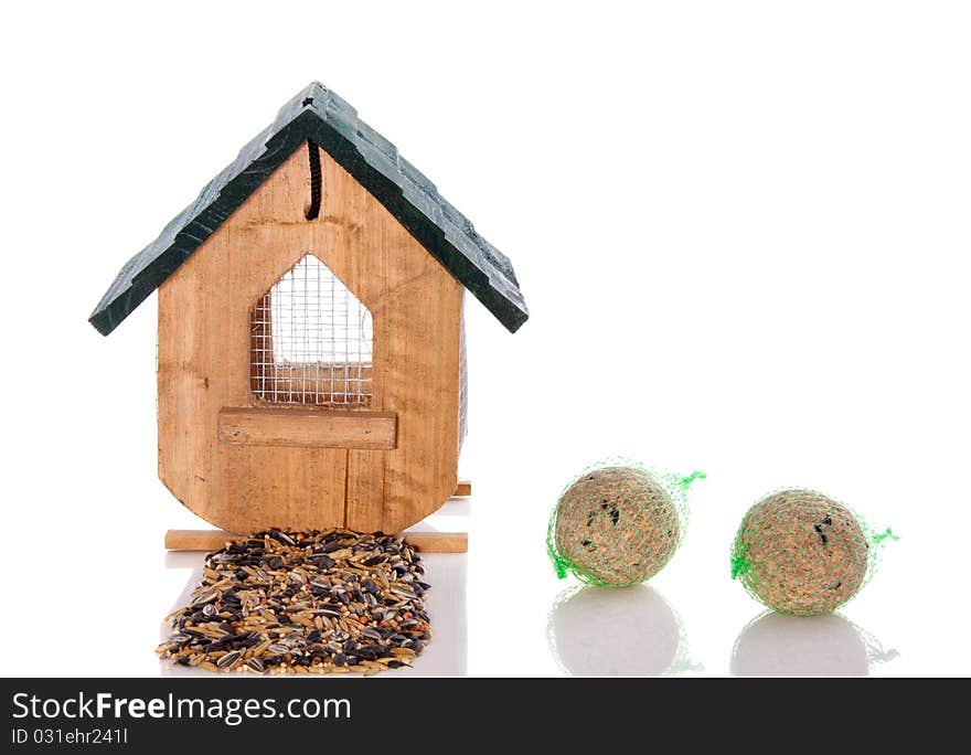 Wooden birdhouse with winter birdseeds and fatballs isolated on white background. Wooden birdhouse with winter birdseeds and fatballs isolated on white background