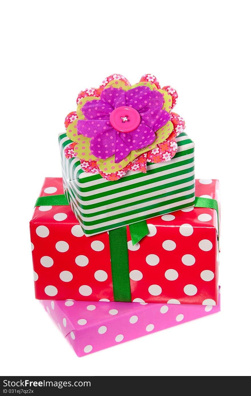 Red green and pink gifts decorated with a fabric cotton flower isolated over white. Red green and pink gifts decorated with a fabric cotton flower isolated over white