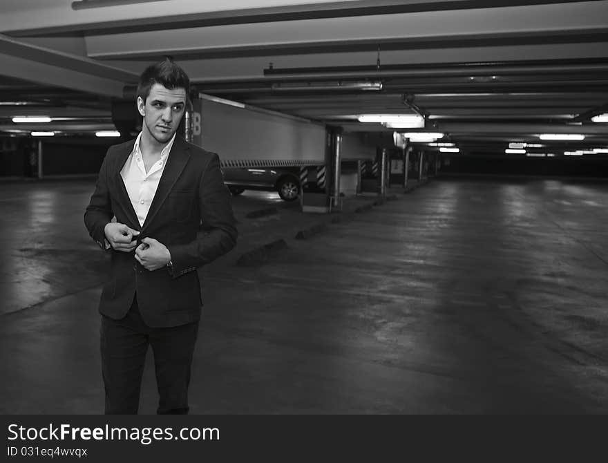 A Businessman getting out of a car in a parking lot. Photo.