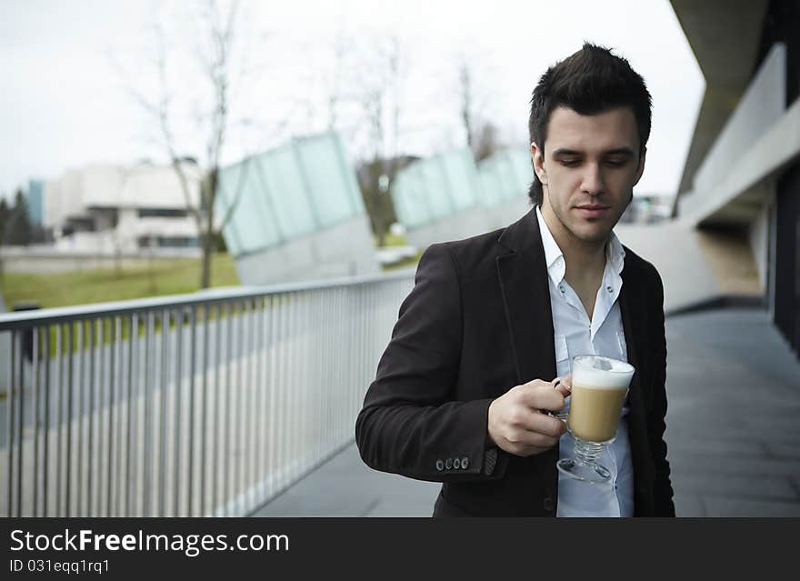 Portrait of Young attractive businessman drinking coffee