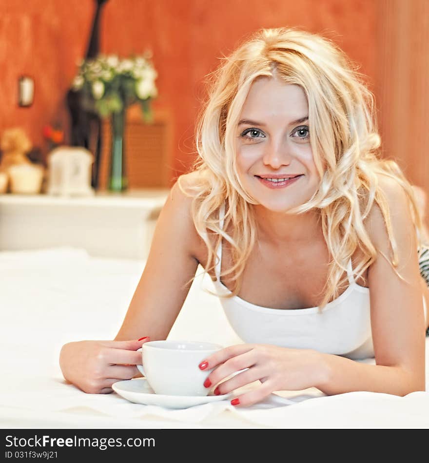 Portrait of a beautiful young lady drinking her morning coffee in couch. Portrait of a beautiful young lady drinking her morning coffee in couch