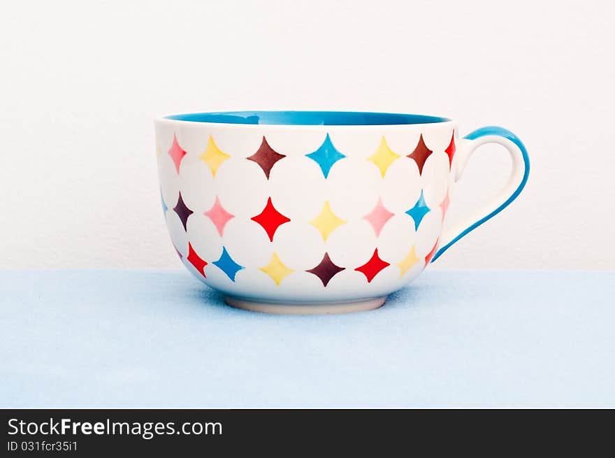 Colorful cup on blue cloth