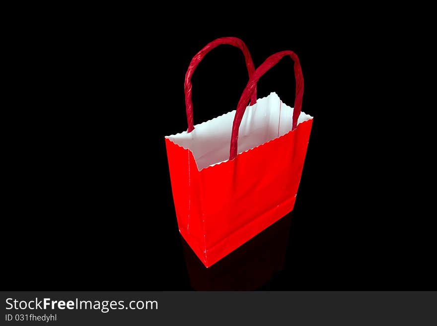 Red shopping bag isolated on black background. Red shopping bag isolated on black background