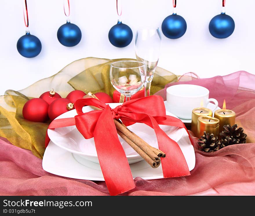 Christmas tableware, decorated with cinnamon sticks, ribbon, christmas balls, candles and cones. Christmas tableware, decorated with cinnamon sticks, ribbon, christmas balls, candles and cones