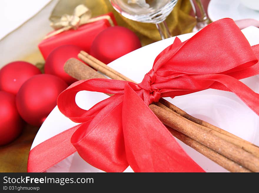 Christmas tableware, decorated with cinnamon sticks, ribbon, christmas balls and cones in close up