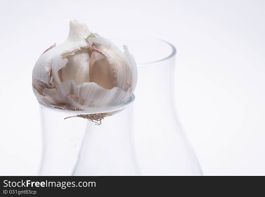 Garlic in a glass on light background. Garlic in a glass on light background