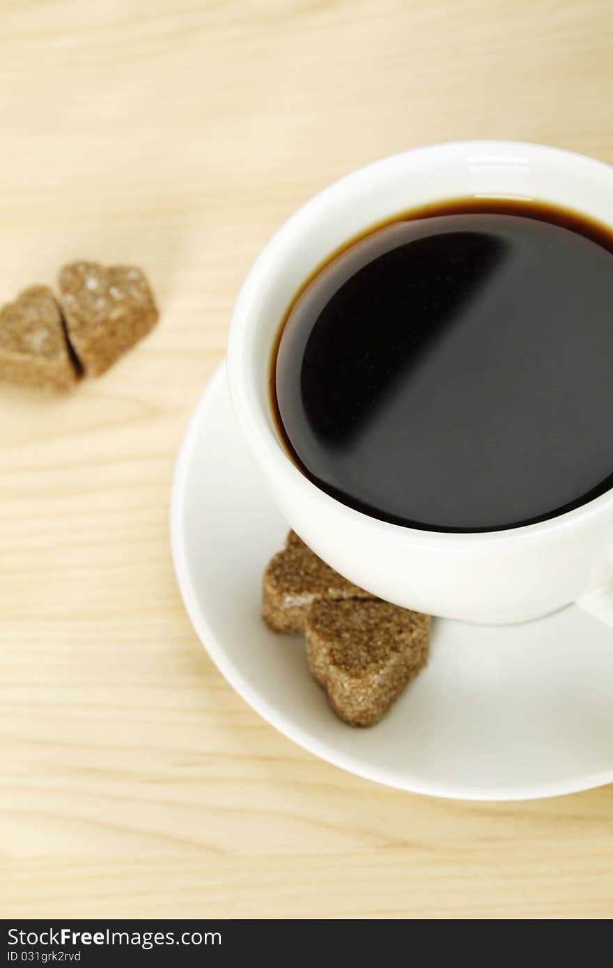 Closeup of a white cup of coffee next to lay pieces of sugar. Closeup of a white cup of coffee next to lay pieces of sugar