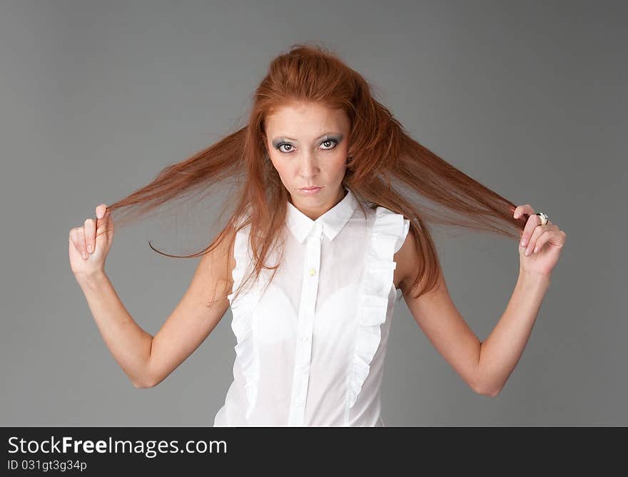 Young beautiful redhead woman. Gray background