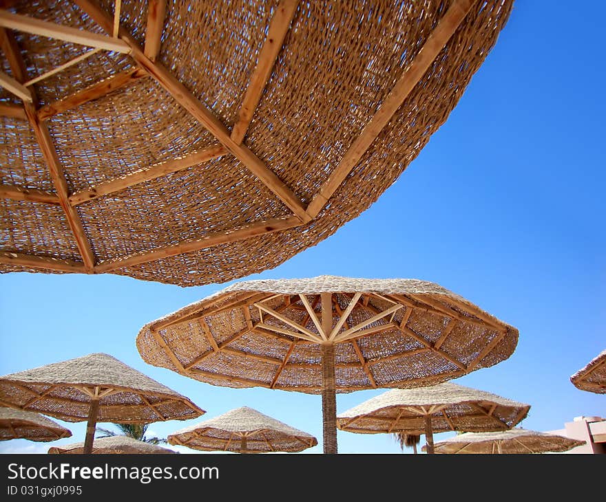 Umbrellas of the beach against a blue sea