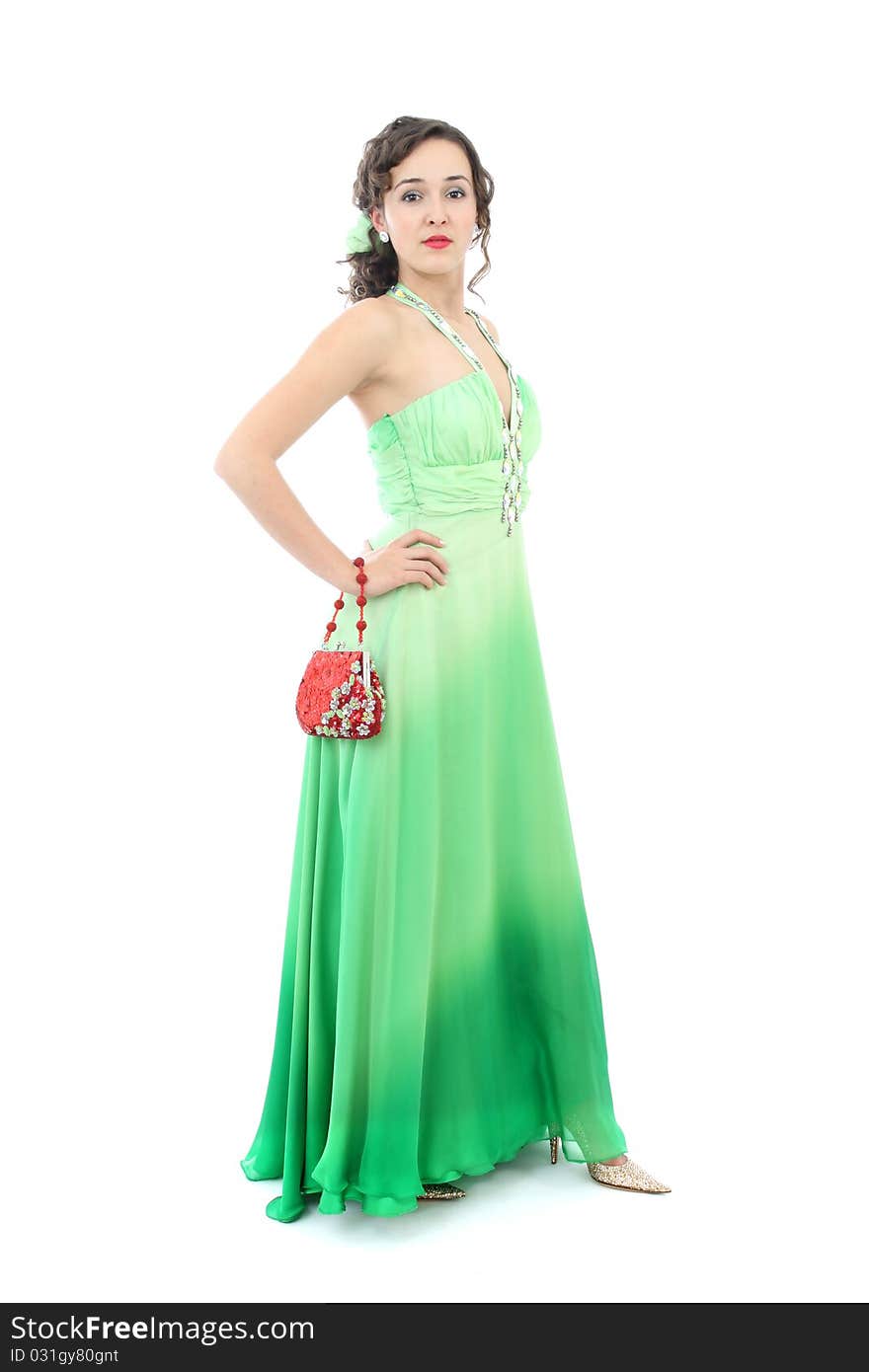 Attractive woman in elegant green dress and red purse isolated on white background