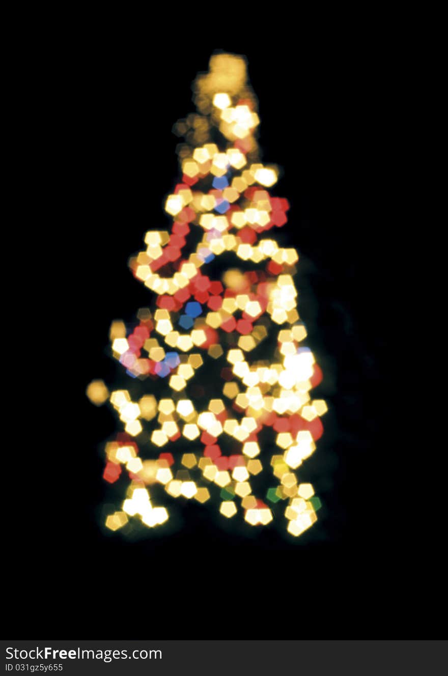 Blurred Christmas tree lights isolated over black.