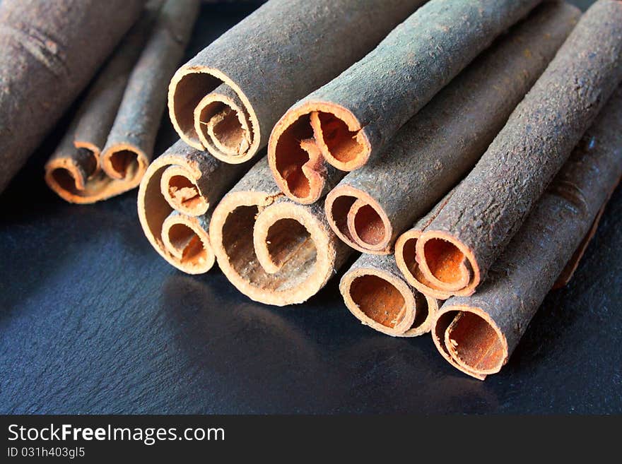 Pile of cinnamon sticks showing their cut and curled edges.