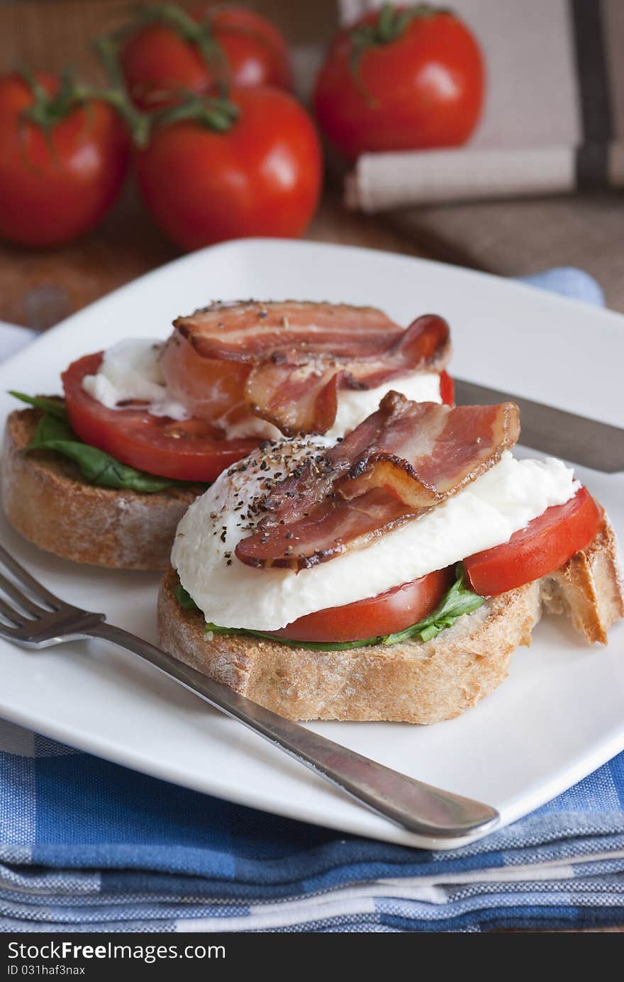 Ciabatta butties with crispy bacon, poached egg and tomatoes. Ciabatta butties with crispy bacon, poached egg and tomatoes