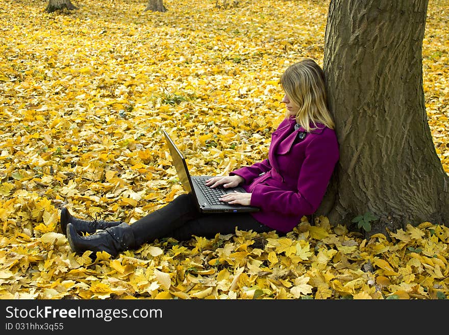 Girl with a laptop near a tree