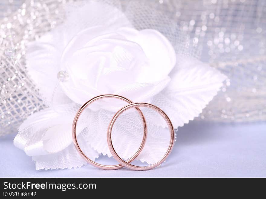 Wedding rings and white satin flower