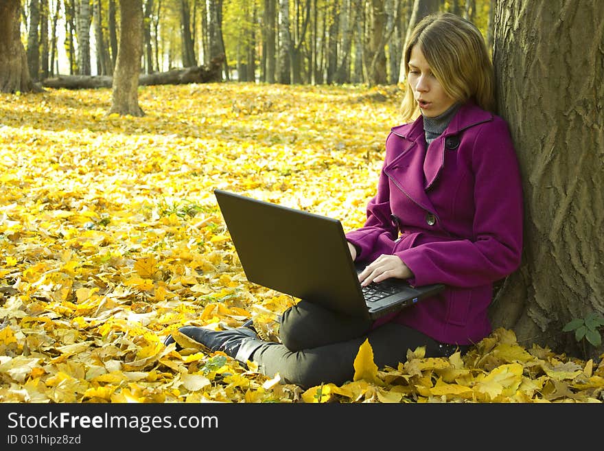 Girl with a laptop near a tree